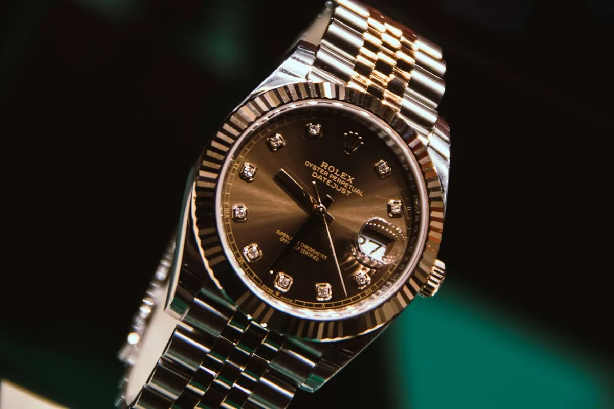 Montre de luxe en acier et or en gros plan, fond vert sombre